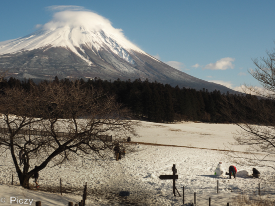 雪で遊ぶ人と富士山