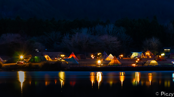 湖畔のキャンプの灯りのリフレクション
